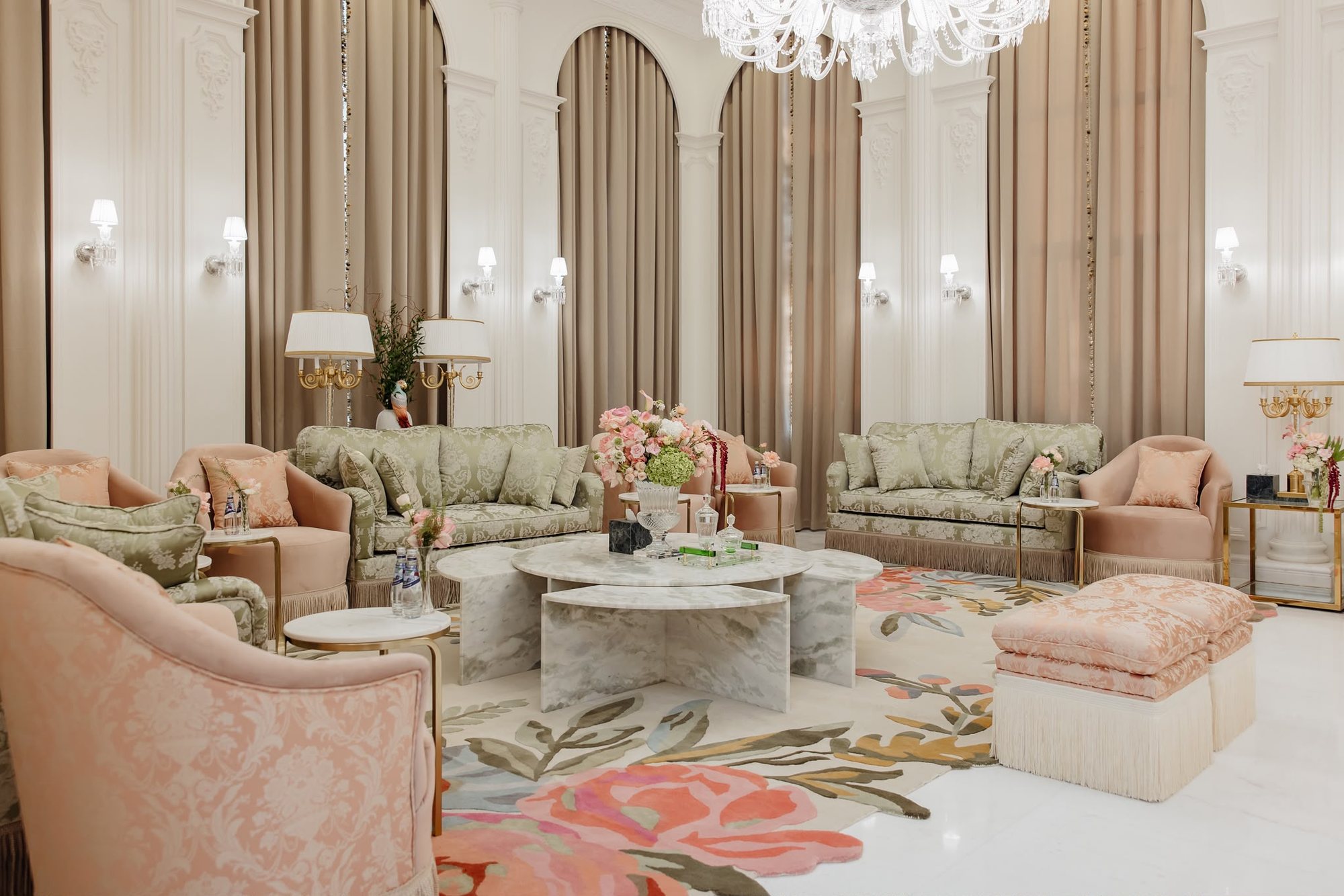 Real project room with sage sofas, blush accents, warm curtains, floral rug, and central marble table